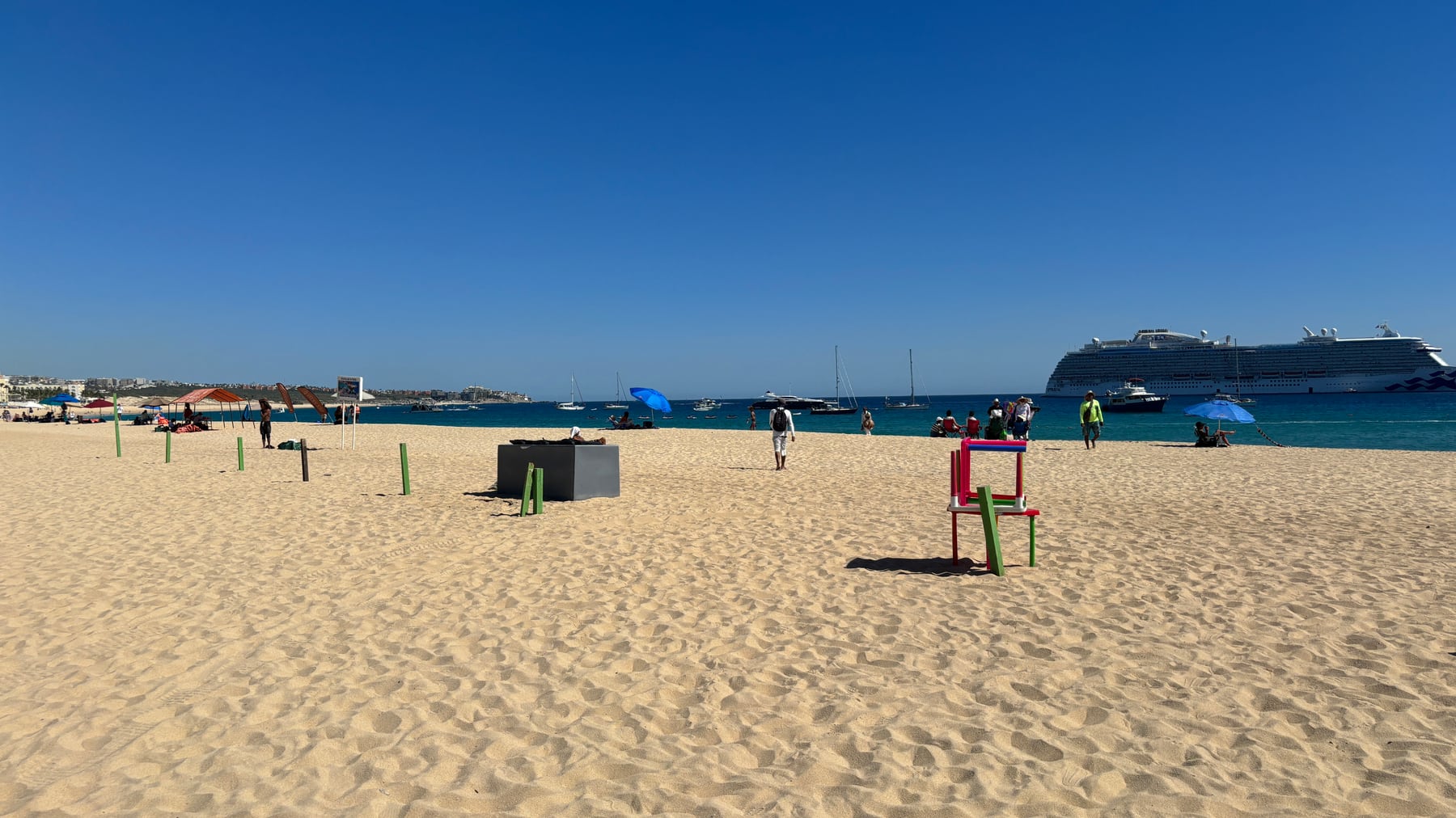 Médano Beach with sand, water, boats and beach activity in Cabo San Lucas.