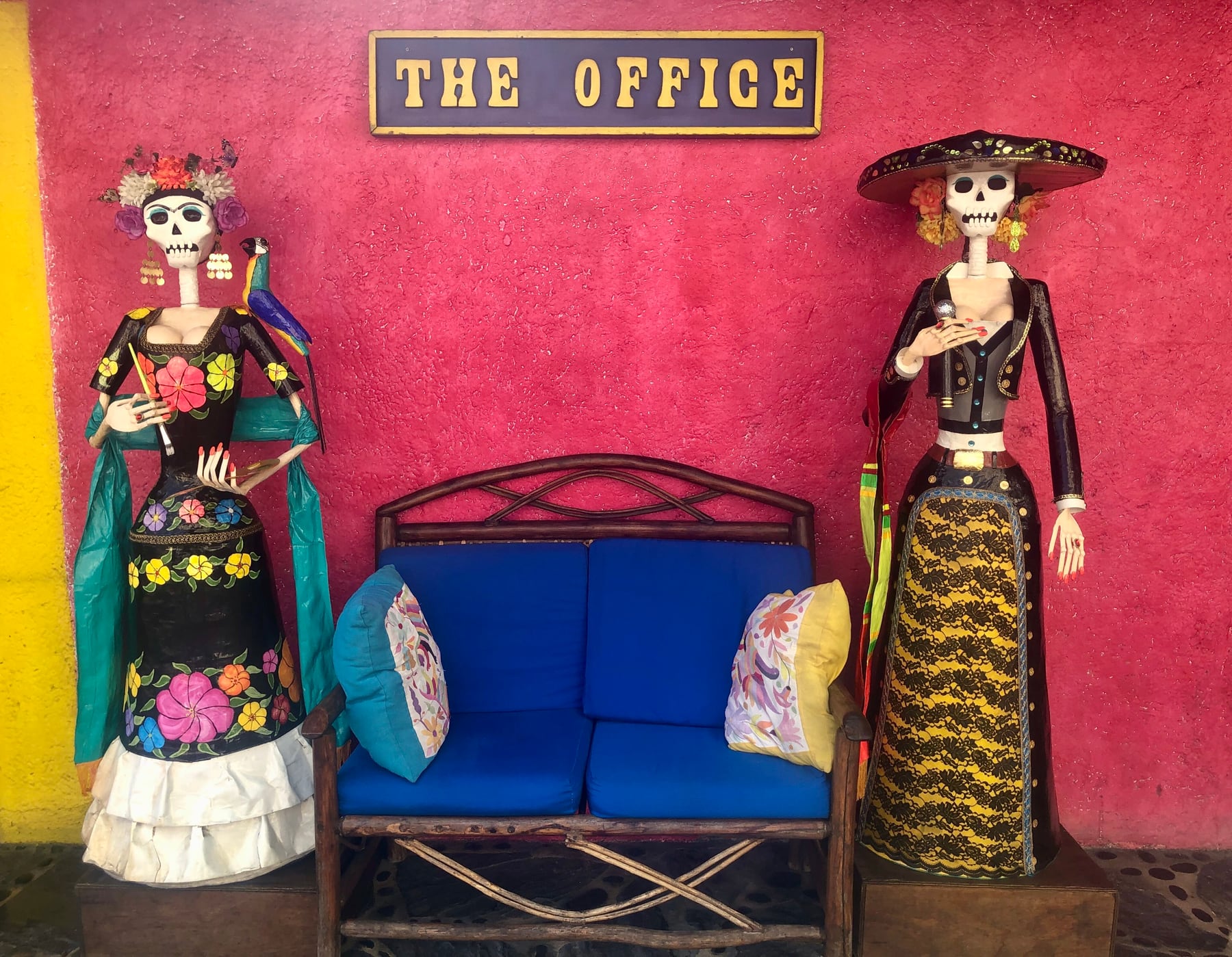 Colorful entrance detail with The Office sign and decorative figures in Cabo San Lucas.